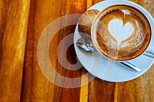 Close up cup of cappuccino in a white cup on a saucer with cookies. Top view copy place