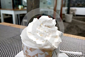 Close-up on a cup of delicious cappuccino. Freshly brewed coffee. Whipped cream.