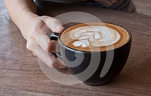 Close up of Cup of hot latte art coffee on wooden table