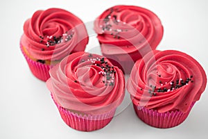 Close up of cupcakes with red buttercream frosting