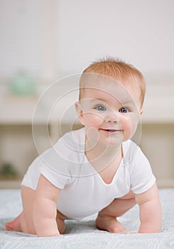 Close up of curious baby crawling on bed