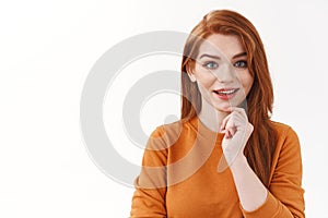 Close-up curious, enthusiastic pretty redhead woman in orange sweater look interested, listen intriguing idea, touching