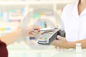 Customer paying with credit card reader in a pharmacy photo