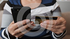 Close up customer holding credit card and smartphone. Female shopper using instant easy mobile payments making purchase