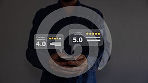 Close up on customer man hand pressing on smartphone screen with gold five star rating feedback icon.