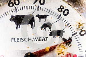 Close-up of the cut of an old mechanical grill thermometer, dirty and ugly at the end of the grill season