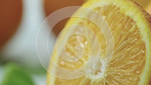 Close-up of a cut orange on which a drop of juice flows.