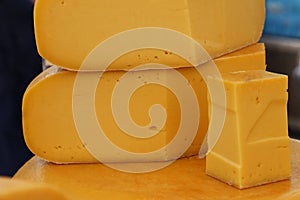 Close up cut slices and wheel of hard gouda cheese