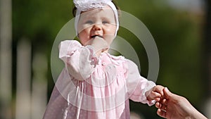 Close-up of the cute baby-girl playing and dancing in the park.