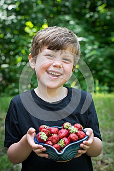 Close up of cute boy smiling with stawberries