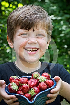 Close up of cute boy smiling with stawberries