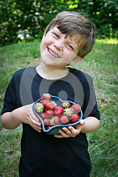 Close up of cute boy smiling with stawberries