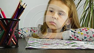 Close up cute child coloring in anti stress book. The concept of psychological relaxation