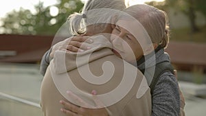 Close up of cute mature couple hugging standing in the street. Elderly family feeling inlove together. People , love