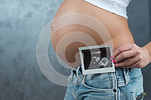 Close up of a cute pregnant belly and ultrasound scan of baby