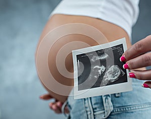 Close up of a cute pregnant belly and ultrasound scan of baby