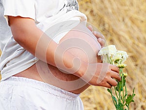 Close up of a cute pregnant belly withn flower
