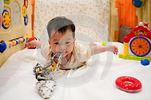 Close-up Cute toddler Girl hold climbing rope , and try flying on white bed in children