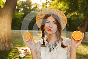 Close up of cute young girl in summer hat spending time at the park