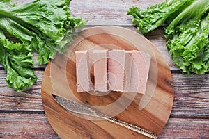 close up of cutting canned meat with a knife on table