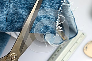 A close up of cutting denim jeans material