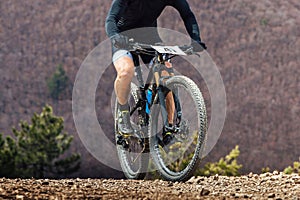 close-up cyclist riding mountain bike in cross-country cycling