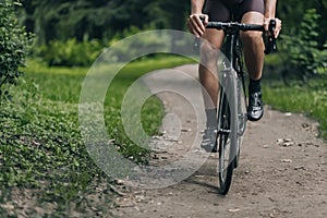 Close up of cyclist with strong legs riding at green park