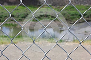 Close up of cyclone fence with river in background