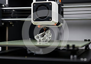 Close up of a 3d printer nozzle creating a detailed object layer by layer