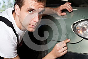 Close-up of damaged car inspected by mechanic