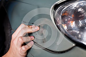 Close-up of damaged car inspected by mechanic