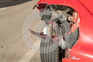 Close-up of a damaged headlamp of a red car