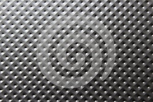 Close-up of a dark gray metal plate with bulges, pimples