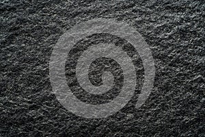 Dark textured stone surface with subtle light play. Neural network AI generated