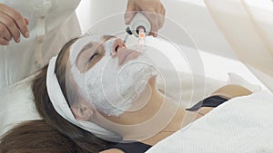Close up darsonvalization face of girl with mask in saloon. Cosmetic procedure