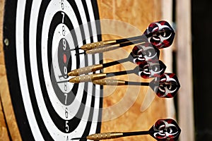 Close up of darts arrows being stuck in the target board