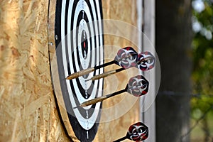 Close up of darts arrows being stuck in the target board