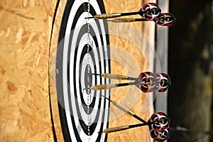 Close up of darts arrows being stuck in the target board