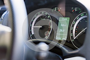 Close up dashboard of a modern car mileage and temperature photo