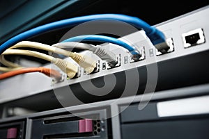 Close-up of data cable plug connected to servers in computer lab