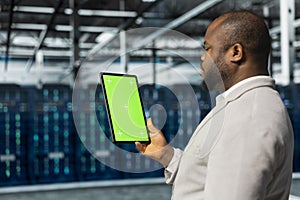 Close up of data center admin using green screen tablet in data center