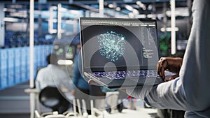 Close up of data center admin using machine learning algorithms on laptop