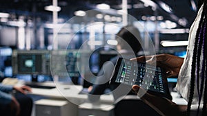 Close up of data center engineer using tablet to review code