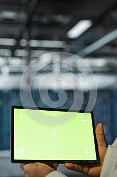 Close up of data center programmer using green screen tablet in data center