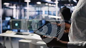 Close up of data center programmer using tablet, writing code
