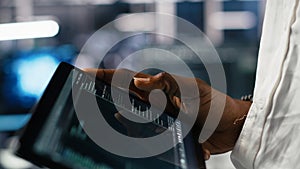 Close up of data center software developer using tablet to review code