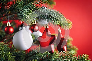 Close up of decorated Christmas tree with red star shaped and white ball shapedl tree ornament baubles