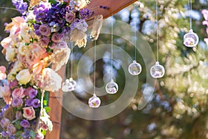 Close-up decoration with fresh flowers of venues. Wedding arch decorated with fresh flowers and hanging glass balls