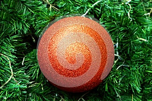 Close up decoration hanging on centre of Christmas tree branches by orange bauble