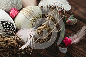 Close up of decorative Easter eggs in a basket on wooden background. Happy Easter card